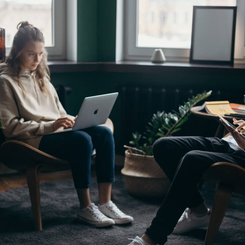 A picture of a man and a woman working on their laptop