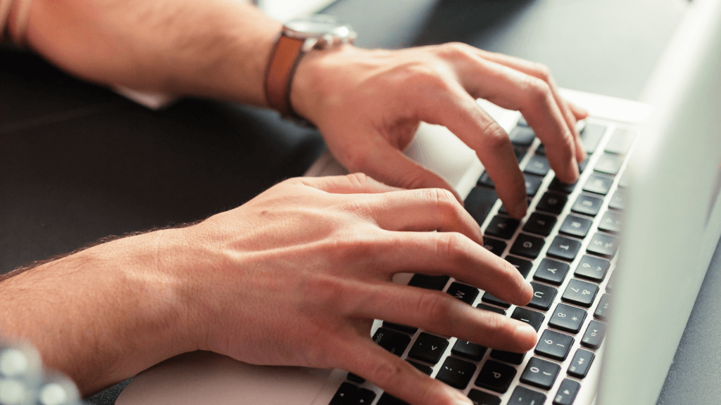 Someone typing on their laptop